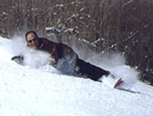 snowboarder carving a fully-laid turn, touching snow