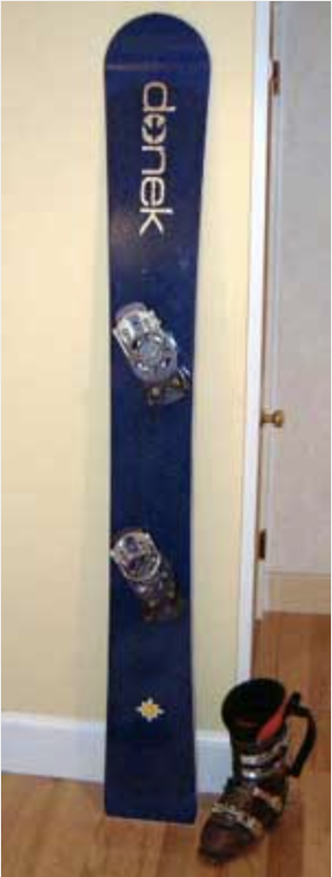 snowboard with mounted bindings resting on wall