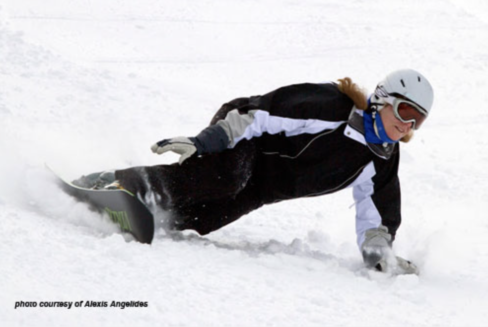 snowboarder carving while highly inclinated, arm touching snow