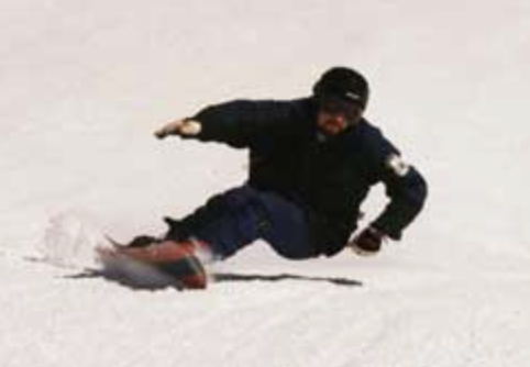 snowboarder pulling a deep heelside carve in good position